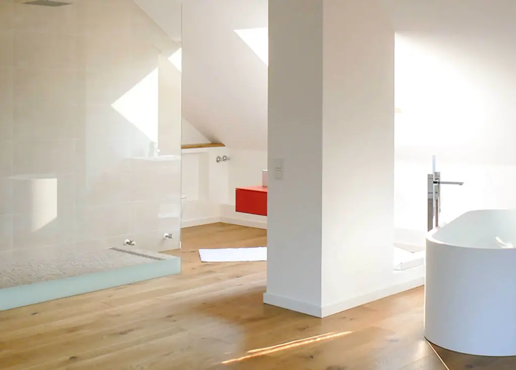Heller Badezimmer-Innenausbau im Dachgeschoss mit freistehender Badewanne und maßgefertigten Einbauten von Schreinerei Engelmann