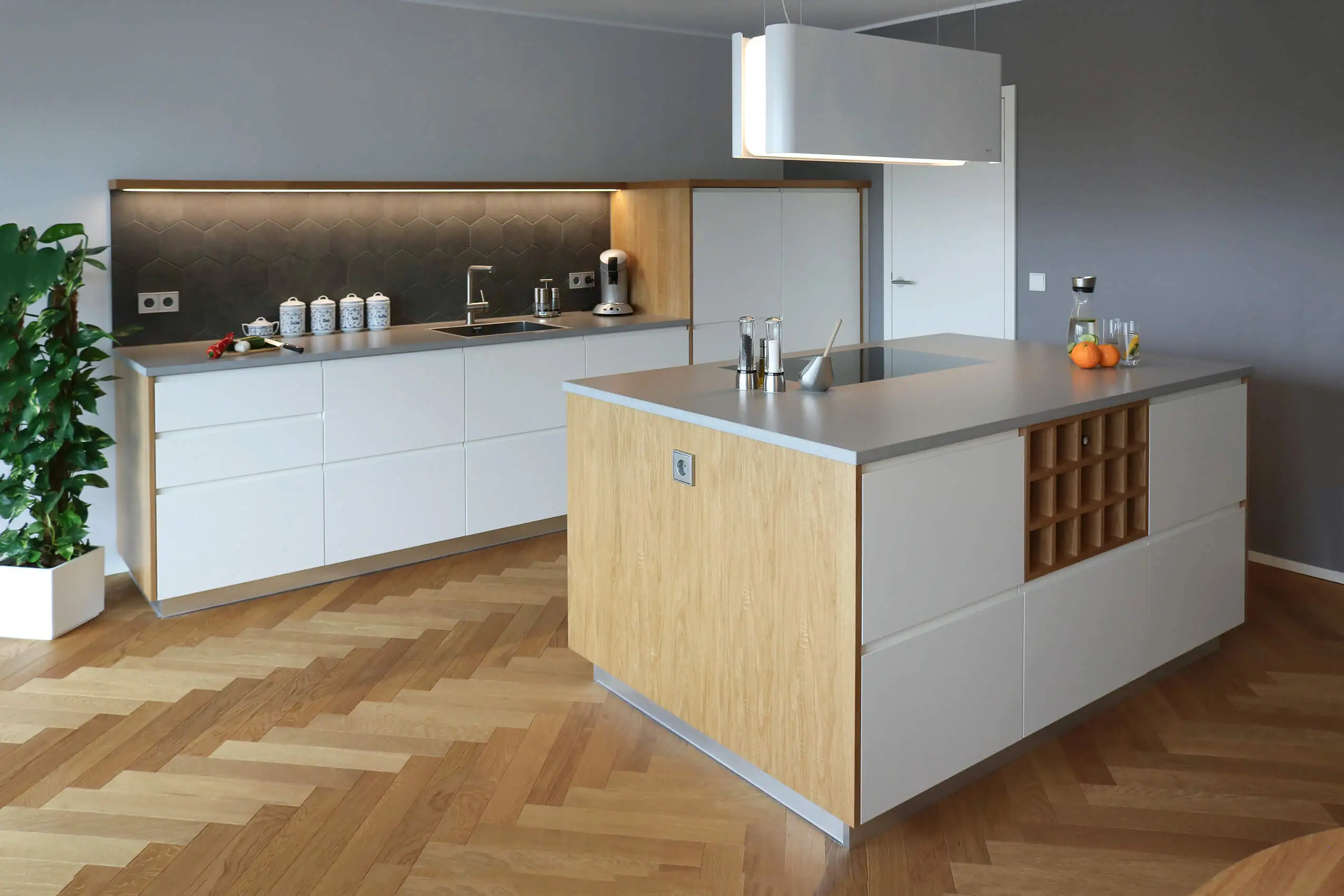 Moderne maßgefertigte Küche mit Kochinsel, heller Front und Holzdetails von Schreinerei Engelmann