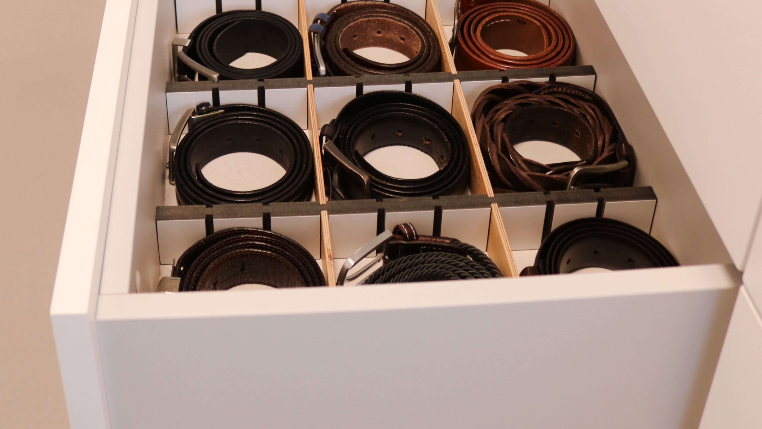 Detail einer maßgefertigten Schublade mit individueller Innenaufteilung für Gürtel