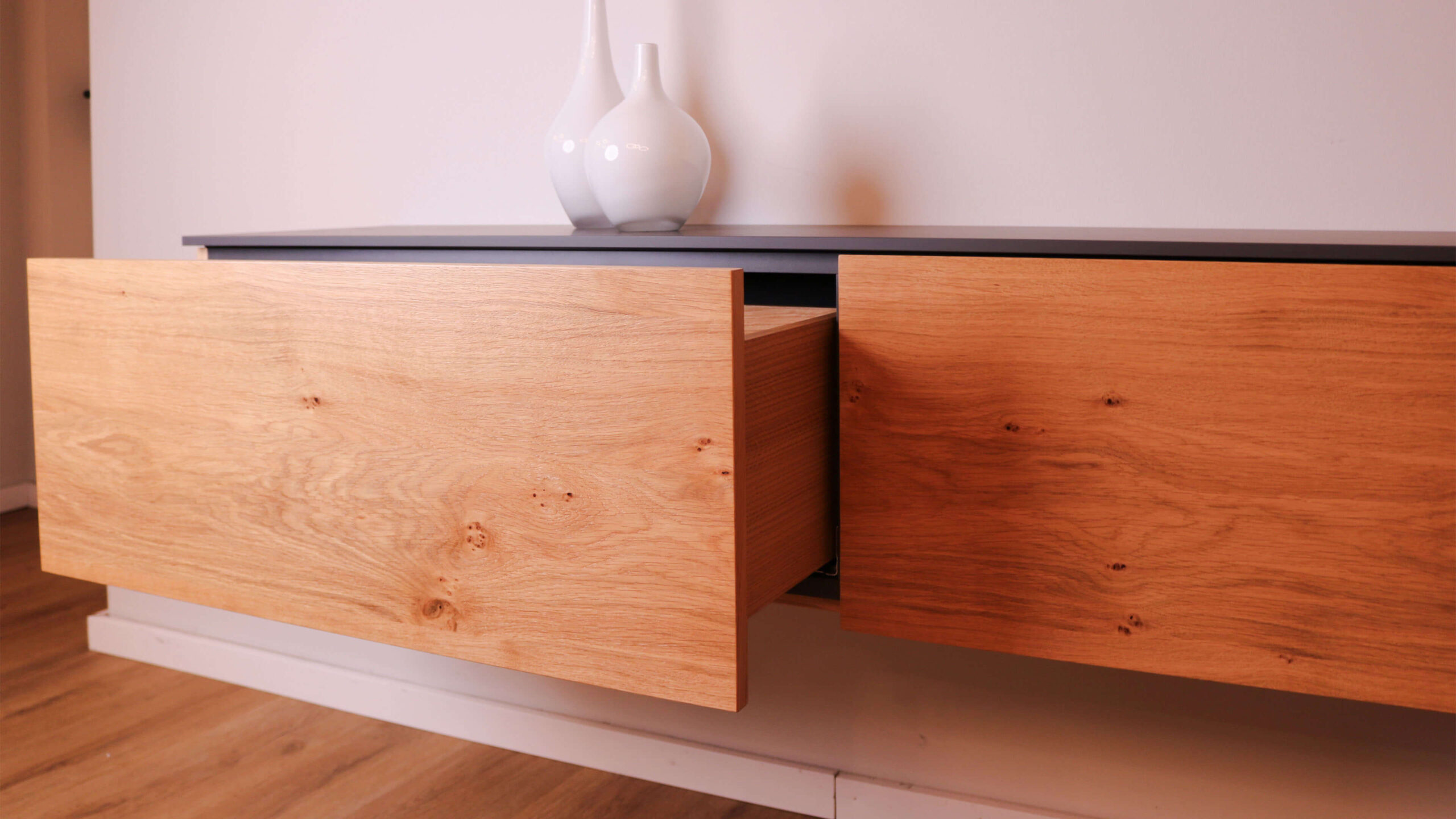 Detailaufnahme einer geöffneten Schublade an einem hängenden Sideboard aus Eiche