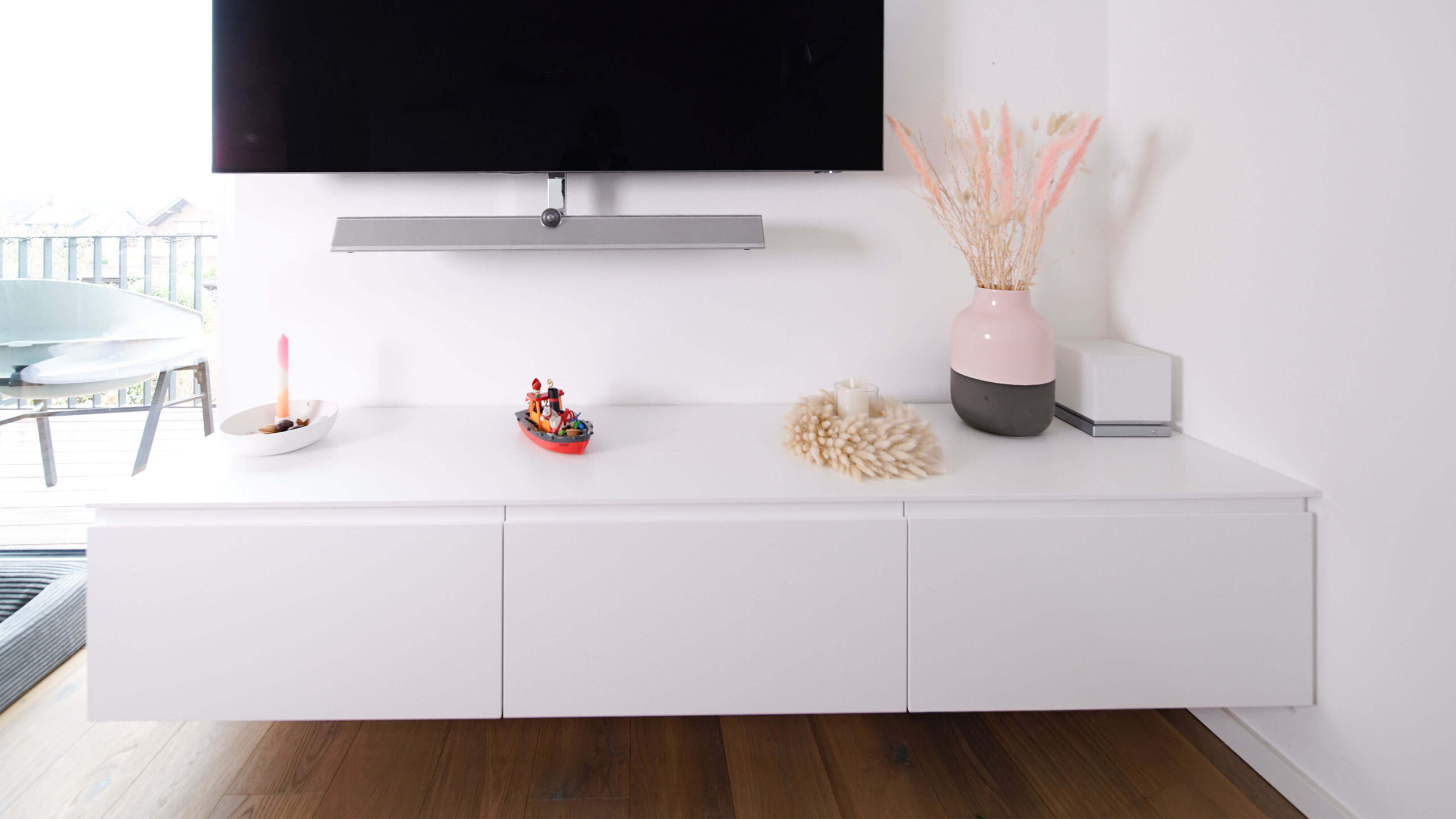 Detailaufnahme einer grifflosen weißen Möbelfront mit präziser Kantenverarbeitung